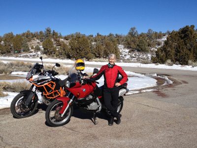 Woman standing next to two motorcycles at SR168 at the Bristlecone rd junction