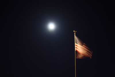 photo of full moon and U.S. flag flying