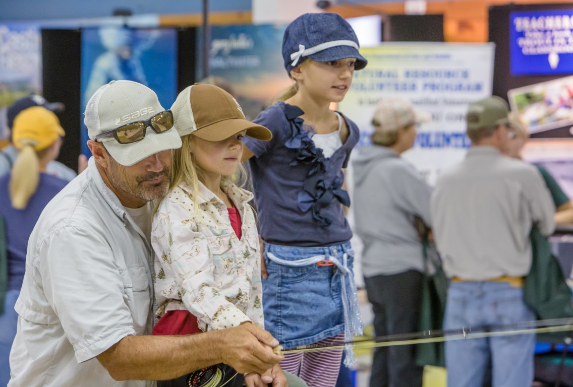 parent teaching kids how to fly fish