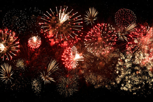 Bright multi-colored fireworks bursting in the night sky over Bishop, California, creating a vibrant display against the stunning backdrop of the Eastern Sierra. visit bishop