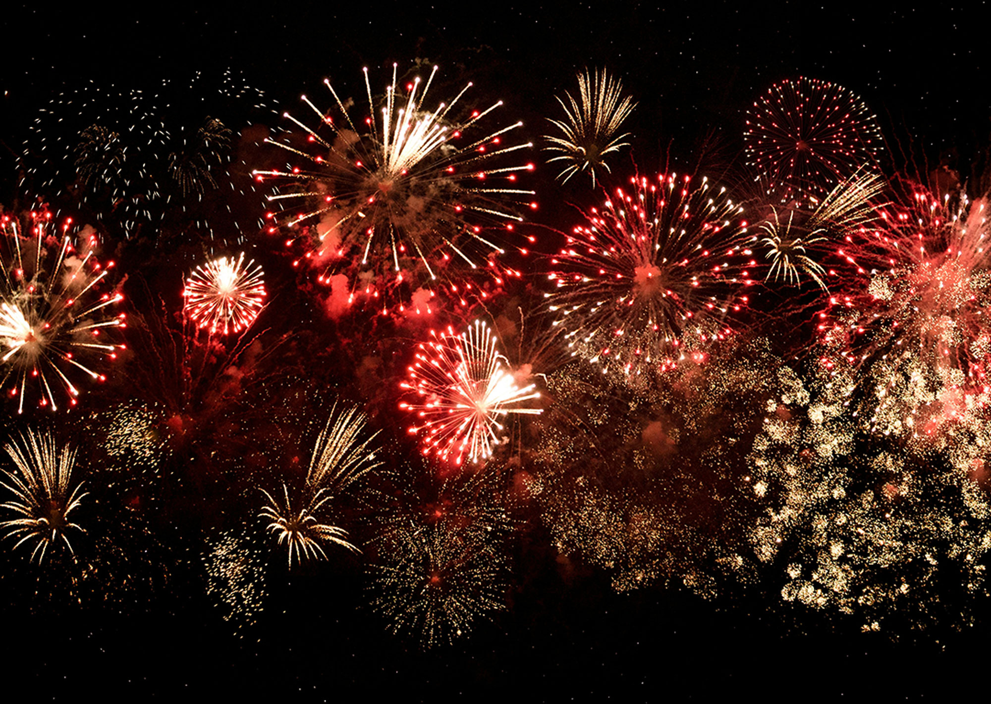 Bright multi-colored fireworks bursting in the night sky over Bishop, California, creating a vibrant display against the stunning backdrop of the Eastern Sierra. visit bishop