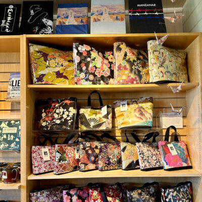 Purses, books, mugs, origami items on sale at Manzanar National Historic Site gift shop.