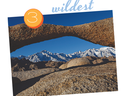 Rocky arch framing a distant snow-capped mountain range under a clear blue sky in Bishop, California, labeled "3 wildest". visit bishop