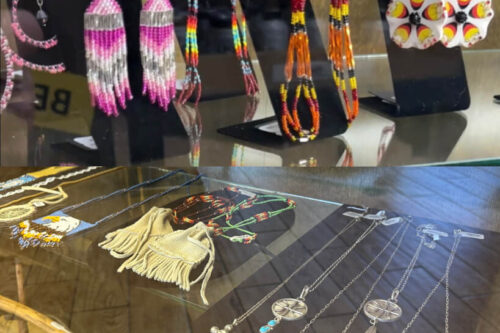 Display of colorful beaded earrings and necklaces on black stands, along with a fringed pouch in a glass case, capturing the essence of Eastern Sierra artistry from Bishop, California. visit bishop