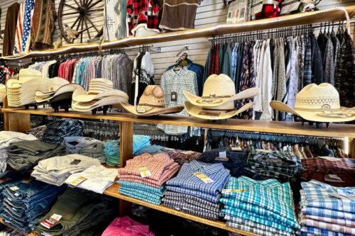 Display of folded shirts, jeans, cowboy hats, and jackets in a Western wear clothing store in Bishop, California. visit bishop